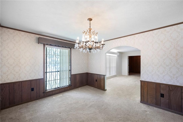 711 W 18th Ter, Russellville, AR 72801 - spare room featuring a wainscoted wall, wallpapered walls, a chandelier, arched walkways, and ornamental molding