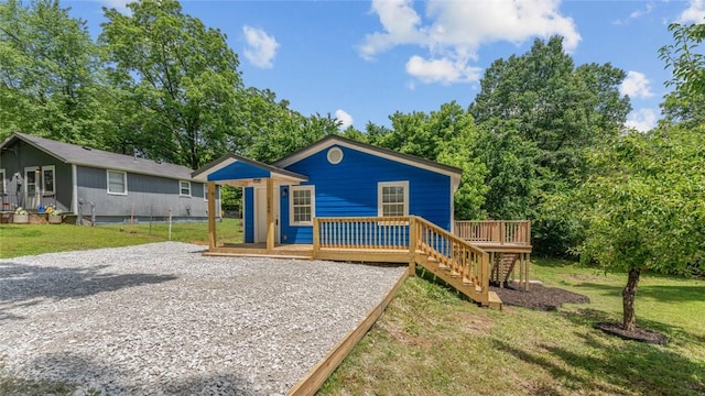 1580 Jones Ln, Pea Ridge, AR 72751 - view of front of home with a deck, a front yard, view of wooded area, and stairway
