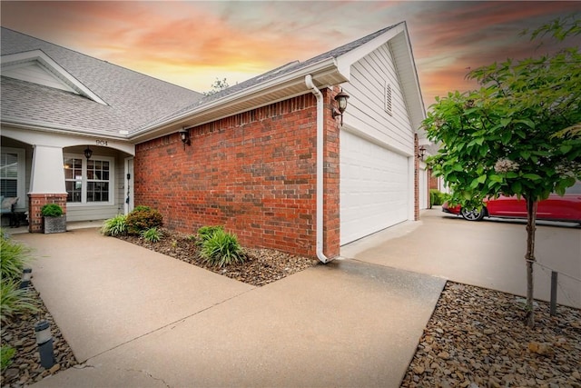 904 S Lafayette St, Rogers, AR 72758 - property exterior at dusk with brick siding, an attached garage, driveway, and a shingled roof