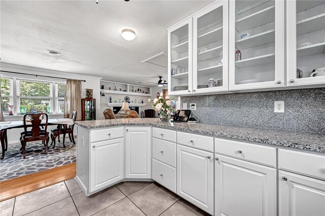 1330 S Baldwin Ave, Fayetteville, AR 72701 - kitchen featuring glass insert cabinets, white cabinetry, light tile patterned floors, and a peninsula