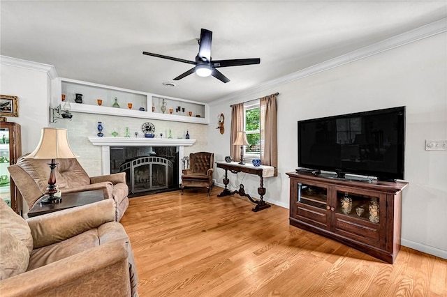 1330 S Baldwin Ave, Fayetteville, AR 72701 - living room with a fireplace, a ceiling fan, light wood-style floors, crown molding, and baseboards
