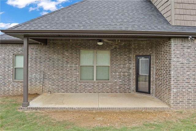 1440 Amber Way, Centerton, AR 72719 - rear view of house featuring a shingled roof, brick siding, and a patio area