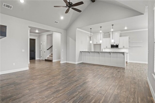 1440 Amber Way, Centerton, AR 72719 - unfurnished living room featuring a ceiling fan, dark wood finished floors, baseboards, high vaulted ceiling, and stairway