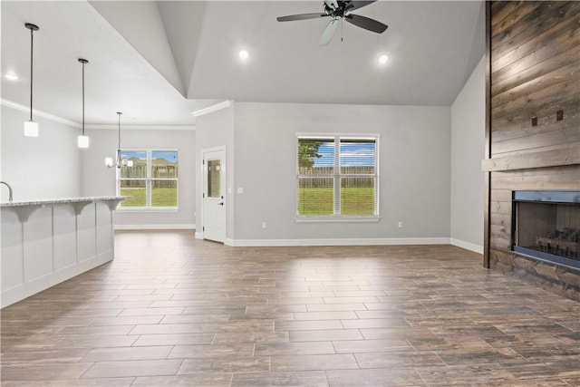 1440 Amber Way, Centerton, AR 72719 - unfurnished living room featuring vaulted ceiling, ceiling fan, a large fireplace, dark wood-type flooring, and baseboards