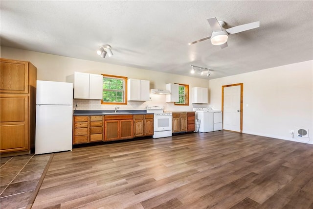 19051 Pinecrest Ln, Rogers, AR 72756 - kitchen with white appliances, washer and clothes dryer, under cabinet range hood, wood finished floors, and tasteful backsplash