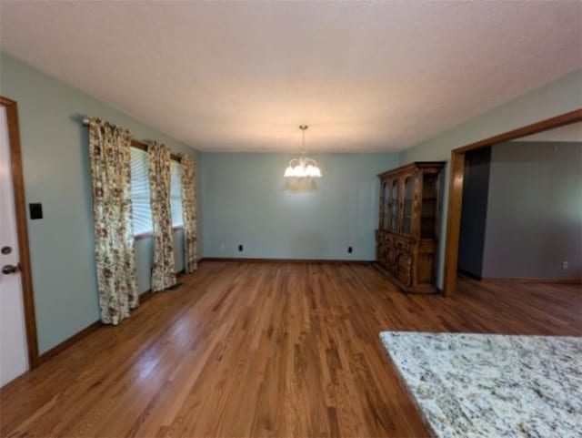 208 Mc 6087, Yellville, AR 72687 - unfurnished dining area with wood finished floors, a chandelier, and baseboards