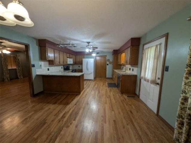 208 Mc 6087, Yellville, AR 72687 - kitchen with white appliances, ceiling fan, a peninsula, light wood-style floors, and brown cabinetry
