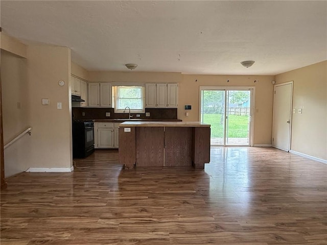 1902 W Granite St, Siloam Springs, AR 72761 - kitchen featuring black gas stove, dark wood-style flooring, a sink, white cabinets, and under cabinet range hood