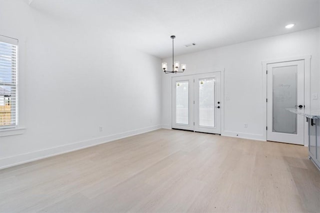 7101 SW Basswood Ave, Bentonville, AR 72713 - unfurnished room with light wood-type flooring, plenty of natural light, a chandelier, and baseboards