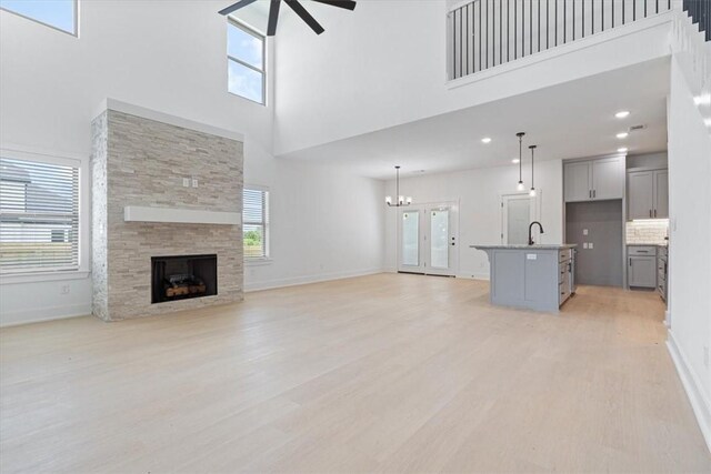 7101 SW Basswood Ave, Bentonville, AR 72713 - unfurnished living room featuring ceiling fan, a high ceiling, light wood-type flooring, plenty of natural light, and recessed lighting