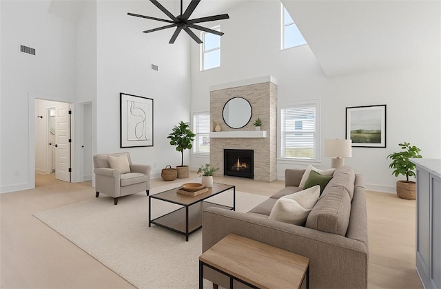 7101 SW Basswood Ave, Bentonville, AR 72713 - living room with a towering ceiling, plenty of natural light, baseboards, a ceiling fan, and a lit fireplace