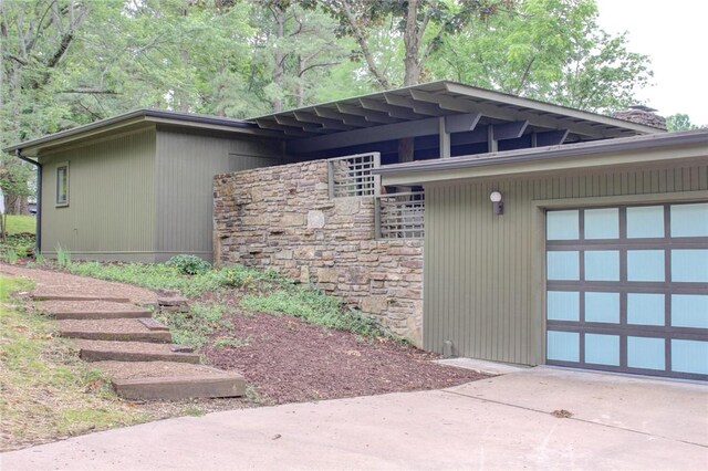 1588 N Tanglebriar Ln, Fayetteville, AR 72701 - view of property exterior featuring driveway, an attached garage, and stone siding