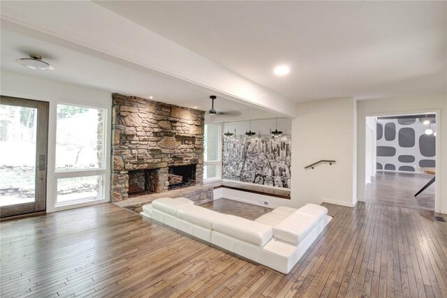 1588 N Tanglebriar Ln, Fayetteville, AR 72701 - living room featuring wood-type flooring, a stone fireplace, and a ceiling fan