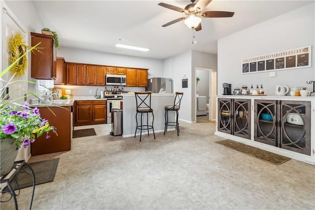 1017 Richland Creek Ave, Elkins, AR 72727 - kitchen featuring appliances with stainless steel finishes, a center island, ceiling fan, a breakfast bar, and light countertops