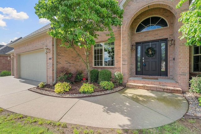 1000 Halifax Pl, Bentonville, AR 72712 - property entrance with an attached garage, brick siding, and concrete driveway