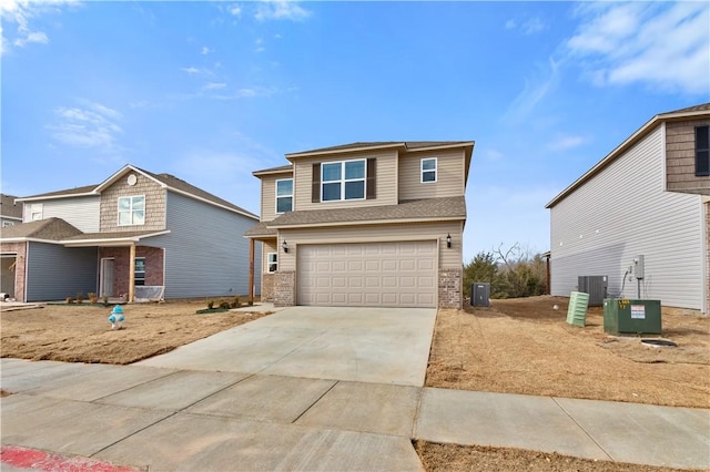 851 E Sparrow Cir, Fayetteville, AR 72701 - view of front of house featuring a garage, driveway, brick siding, and central AC unit