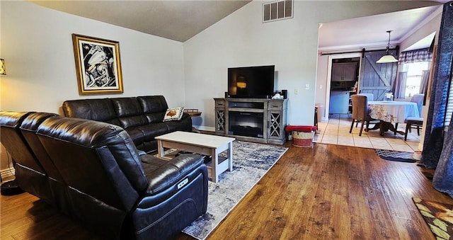 4158 N Rocky Ridge Trl, Rogers, AR 72756 - living room with vaulted ceiling, hardwood / wood-style flooring, a barn door, and baseboards