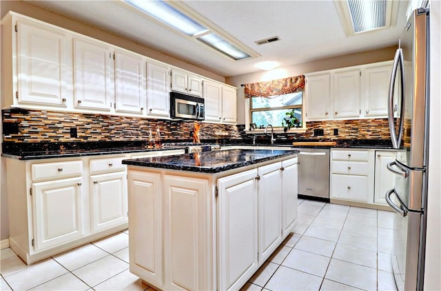 811 E Township St, Fayetteville, AR 72703 - kitchen with stainless steel appliances, a kitchen island, tasteful backsplash, light tile patterned floors, and a sink
