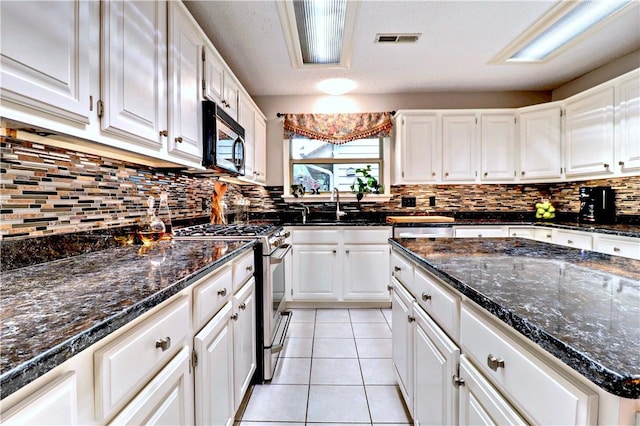 811 E Township St, Fayetteville, AR 72703 - kitchen featuring stainless steel appliances, white cabinetry, backsplash, and a sink
