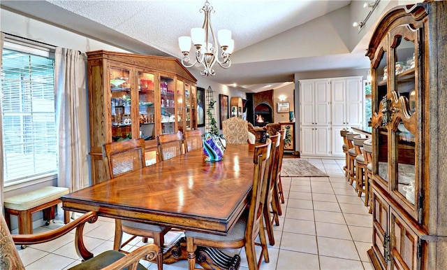 811 E Township St, Fayetteville, AR 72703 - dining area featuring vaulted ceiling, light tile patterned floors, a chandelier, and a textured ceiling