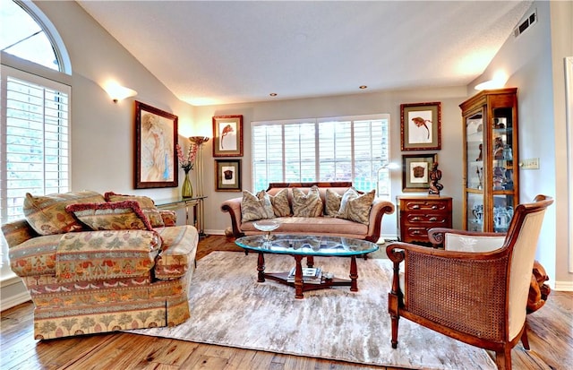 811 E Township St, Fayetteville, AR 72703 - living room with healthy amount of natural light, wood finished floors, vaulted ceiling, and baseboards