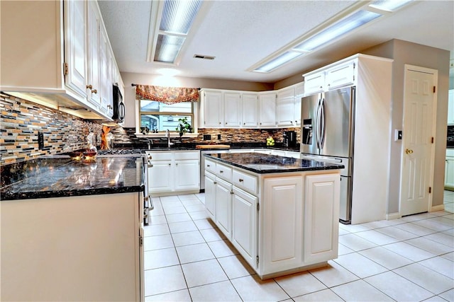 811 E Township St, Fayetteville, AR 72703 - kitchen featuring stainless steel fridge with ice dispenser, a sink, tasteful backsplash, and light tile patterned floors