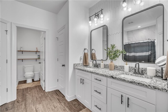 1461 Colonel Mcneil Dr, Prairie Grove, AR 72753 - full bath featuring double vanity, toilet, wood finished floors, curtained shower, and baseboards