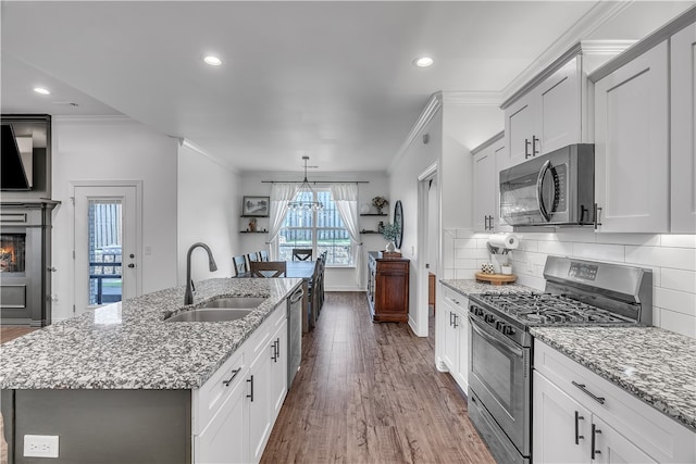 1461 Colonel Mcneil Dr, Prairie Grove, AR 72753 - kitchen featuring appliances with stainless steel finishes, a sink, crown molding, an island with sink, and wood finished floors