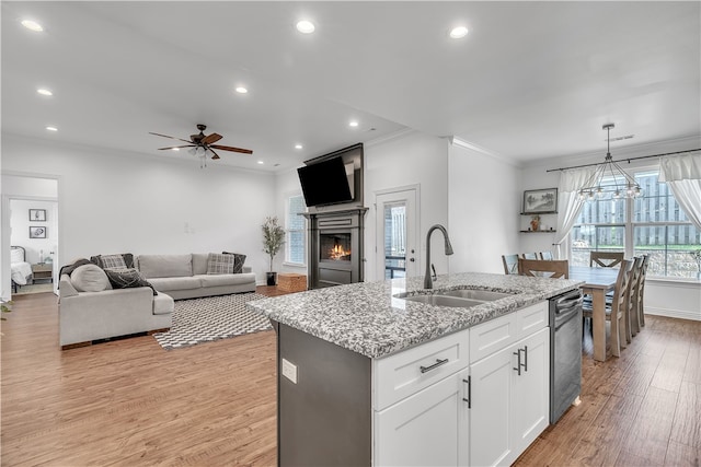 1461 Colonel Mcneil Dr, Prairie Grove, AR 72753 - kitchen with a sink, stainless steel dishwasher, a lit fireplace, light wood-type flooring, and ornamental molding