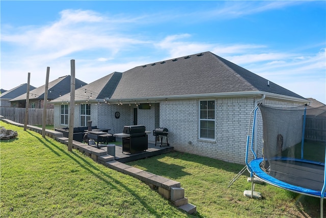 1461 Colonel Mcneil Dr, Prairie Grove, AR 72753 - rear view of property featuring a trampoline, an outdoor hangout area, a shingled roof, brick siding, and a patio