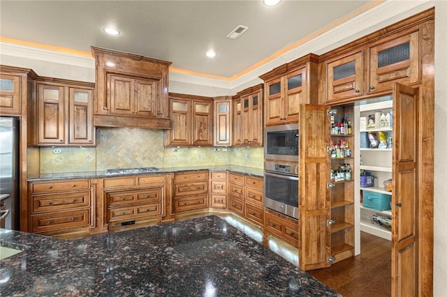 3504 NW Edgewood Ave, Bentonville, AR 72712 - kitchen featuring stainless steel appliances, brown cabinetry, crown molding, backsplash, and dark stone counters