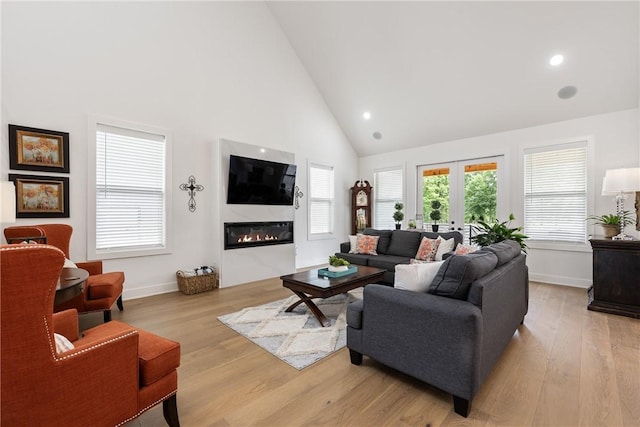 301 SW Autumn Hills Rd, Bentonville, AR 72712 - living area featuring high vaulted ceiling, light wood-style flooring, a glass covered fireplace, baseboards, and recessed lighting