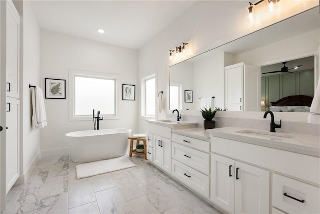301 SW Autumn Hills Rd, Bentonville, AR 72712 - full bath with marble finish flooring, double vanity, a ceiling fan, a freestanding bath, and baseboards
