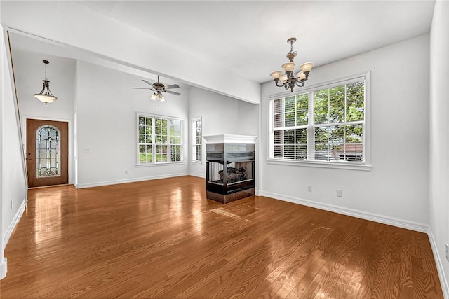 4801 SW Golden Eagle Ave, Bentonville, AR 72713 - unfurnished living room featuring a chandelier, wood finished floors, baseboards, a multi sided fireplace, and a ceiling fan