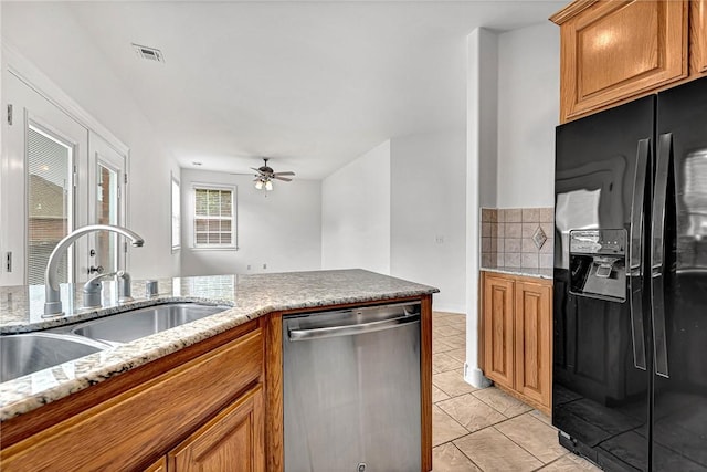 4801 SW Golden Eagle Ave, Bentonville, AR 72713 - kitchen with black fridge with ice dispenser, dishwasher, a sink, a ceiling fan, and light stone counters