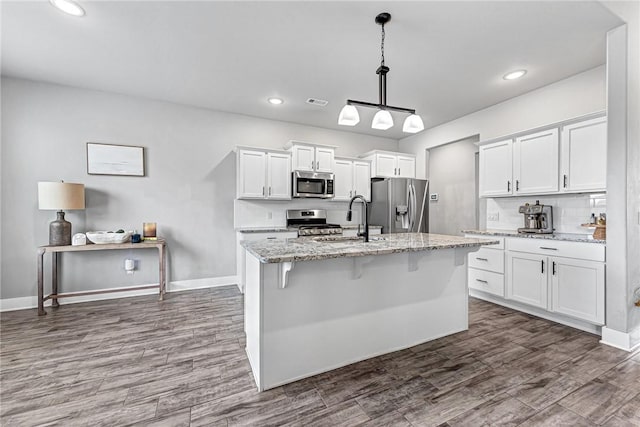 1140 Durante St, Tontitown, AR 72762 - kitchen with appliances with stainless steel finishes, a sink, white cabinets, a center island with sink, and recessed lighting