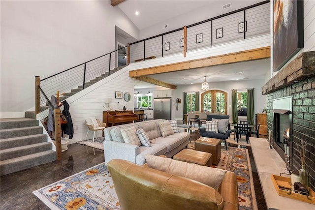 112 E Woodside Ln, Rogers, AR 72756 - living room featuring a high ceiling, stairway, concrete flooring, a lit fireplace, and recessed lighting