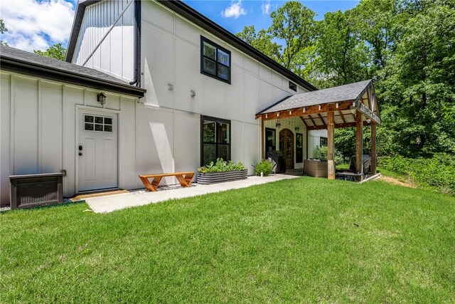 112 E Woodside Ln, Rogers, AR 72756 - rear view of house featuring board and batten siding, a yard, and a shingled roof