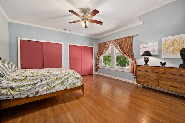615 E Prairie Creek Dr, Rogers, AR 72756 - bedroom with two closets, wood finished floors, baseboards, ornamental molding, and a ceiling fan
