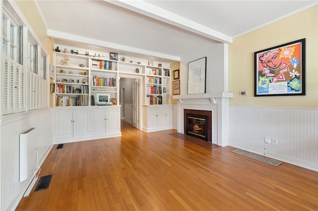 615 E Prairie Creek Dr, Rogers, AR 72756 - unfurnished living room with wainscoting, hardwood / wood-style floors, a brick fireplace, built in shelves, and crown molding