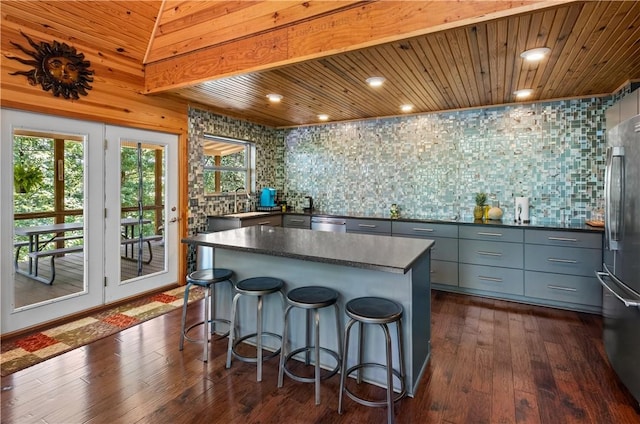 482 County Road 332, Eureka Springs, AR 72632 - kitchen with dark countertops, gray cabinets, stainless steel appliances, a center island, and decorative backsplash