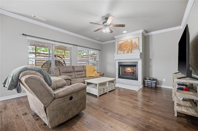 1320 Lariat Dr, Centerton, AR 72719 - living room featuring wood finished floors, a ceiling fan, a warm lit fireplace, baseboards, and ornamental molding