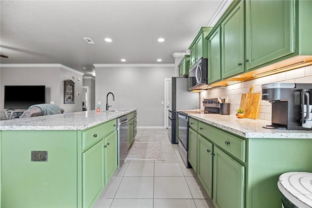 1320 Lariat Dr, Centerton, AR 72719 - kitchen with green cabinetry, stainless steel appliances, a kitchen island with sink, a sink, and ornamental molding