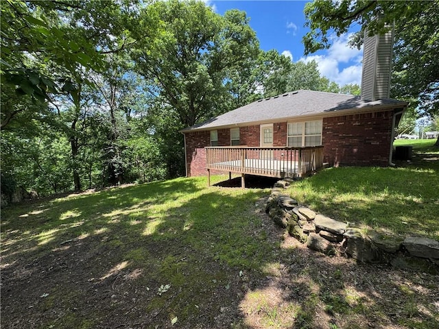 12305 Tyson Rd, Lowell, AR 72745 - back of house with a wooden deck, a chimney, brick siding, and a lawn