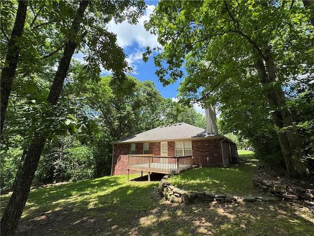 12305 Tyson Rd, Lowell, AR 72745 - back of property featuring brick siding, a deck, a yard, and a chimney