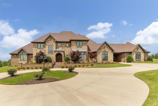 4465 Champagne Dr, Springdale, AR 72764 - french provincial home with curved driveway, stone siding, and a front lawn
