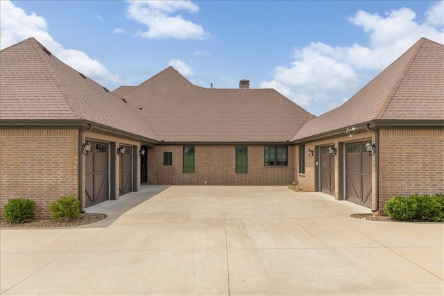 4465 Champagne Dr, Springdale, AR 72764 - back of property featuring brick siding, concrete driveway, a garage, and roof with shingles