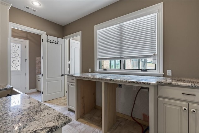 4465 Champagne Dr, Springdale, AR 72764 - kitchen featuring light stone countertops, white cabinetry, and a desk