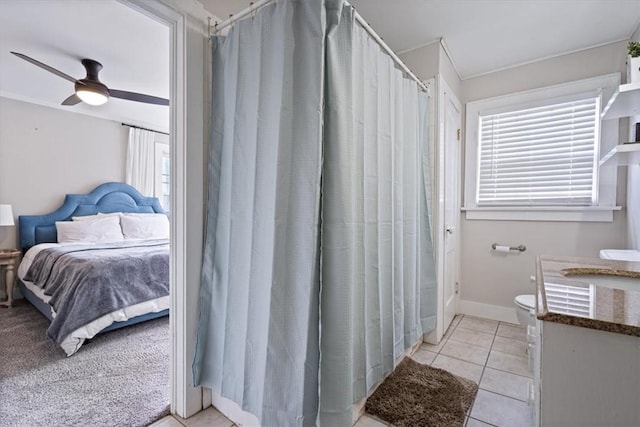 626 Ash St, Fayetteville, AR 72703 - full bathroom with connected bathroom, a ceiling fan, a shower with shower curtain, tile patterned flooring, and toilet