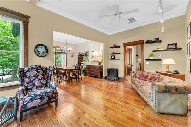 11 Hilton St, Eureka Springs, AR 72632 - living room with a ceiling fan, a wood stove, light wood-style floors, a chandelier, and ornamental molding